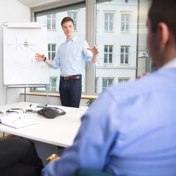 Businessman Gesturing While Giving Presentation To Colleagues