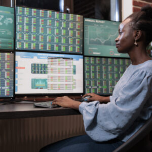 Hedge fund company professional employee sitting at multi monitor workstation