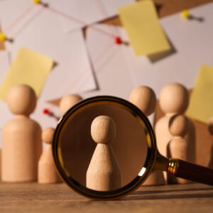 A wooden figurine under a magnifying glass